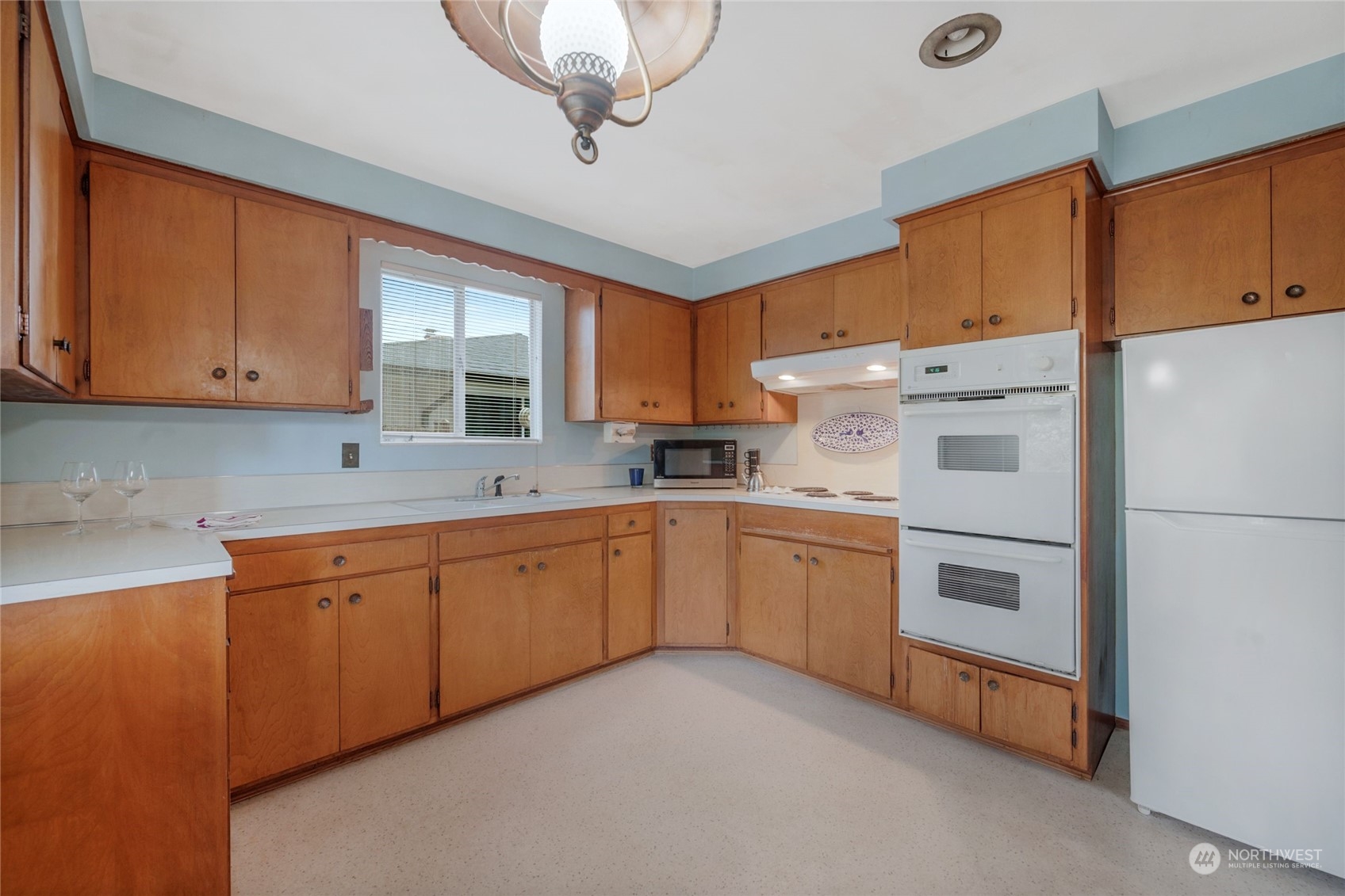 5025 West Highland Road Everett, WA 98203 - Photo 8 of 24 a kitchen with granite countertop white cabinets and white appliances