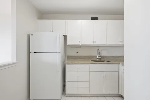 a kitchen with granite countertop white cabinets and white appliances