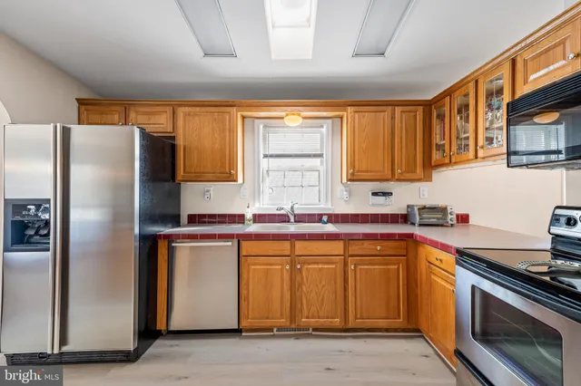 a kitchen with stainless steel appliances granite countertop a refrigerator sink and stove