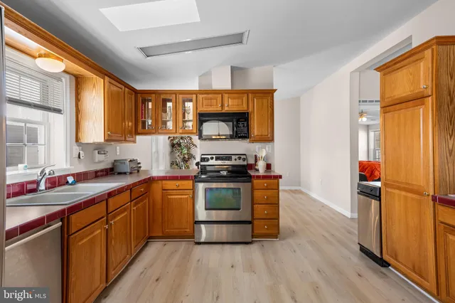 a kitchen with stainless steel appliances granite countertop a stove a sink dishwasher and a refrigerator