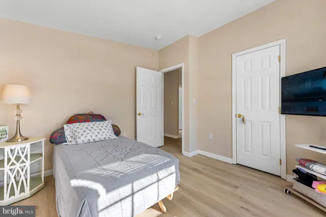 a view of a bedroom with a bed and wooden floor
