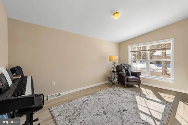 a spacious bedroom with a bed and wooden floor
