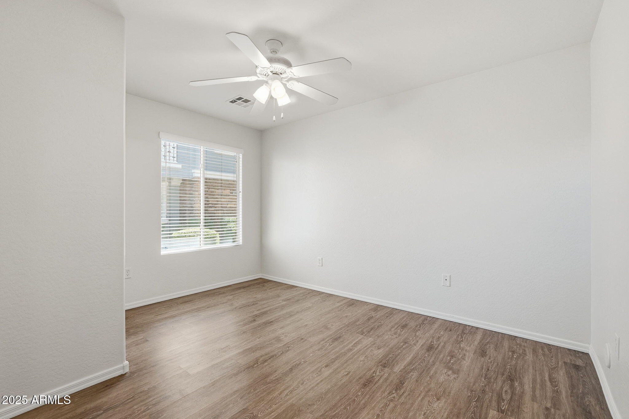 9233 East Neville Avenue, Unit 1136 Mesa, AZ 85209 - Photo 14 of 29 an empty room with wooden floor and windows