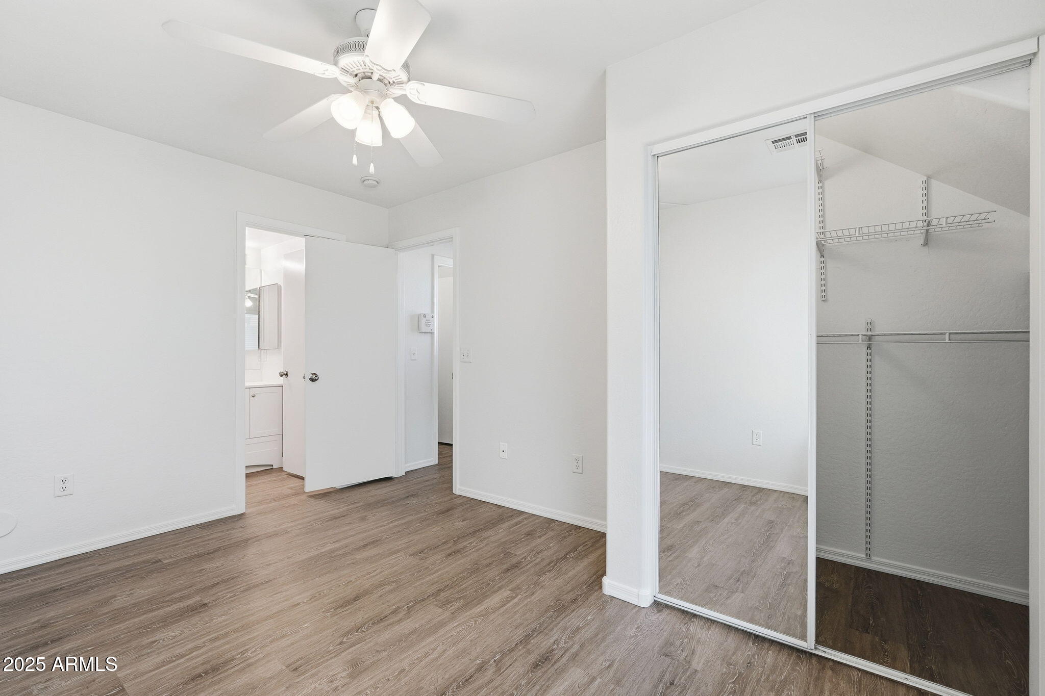 9233 East Neville Avenue, Unit 1136 Mesa, AZ 85209 - Photo 16 of 29 an empty room with wooden floor and a ceiling fan
