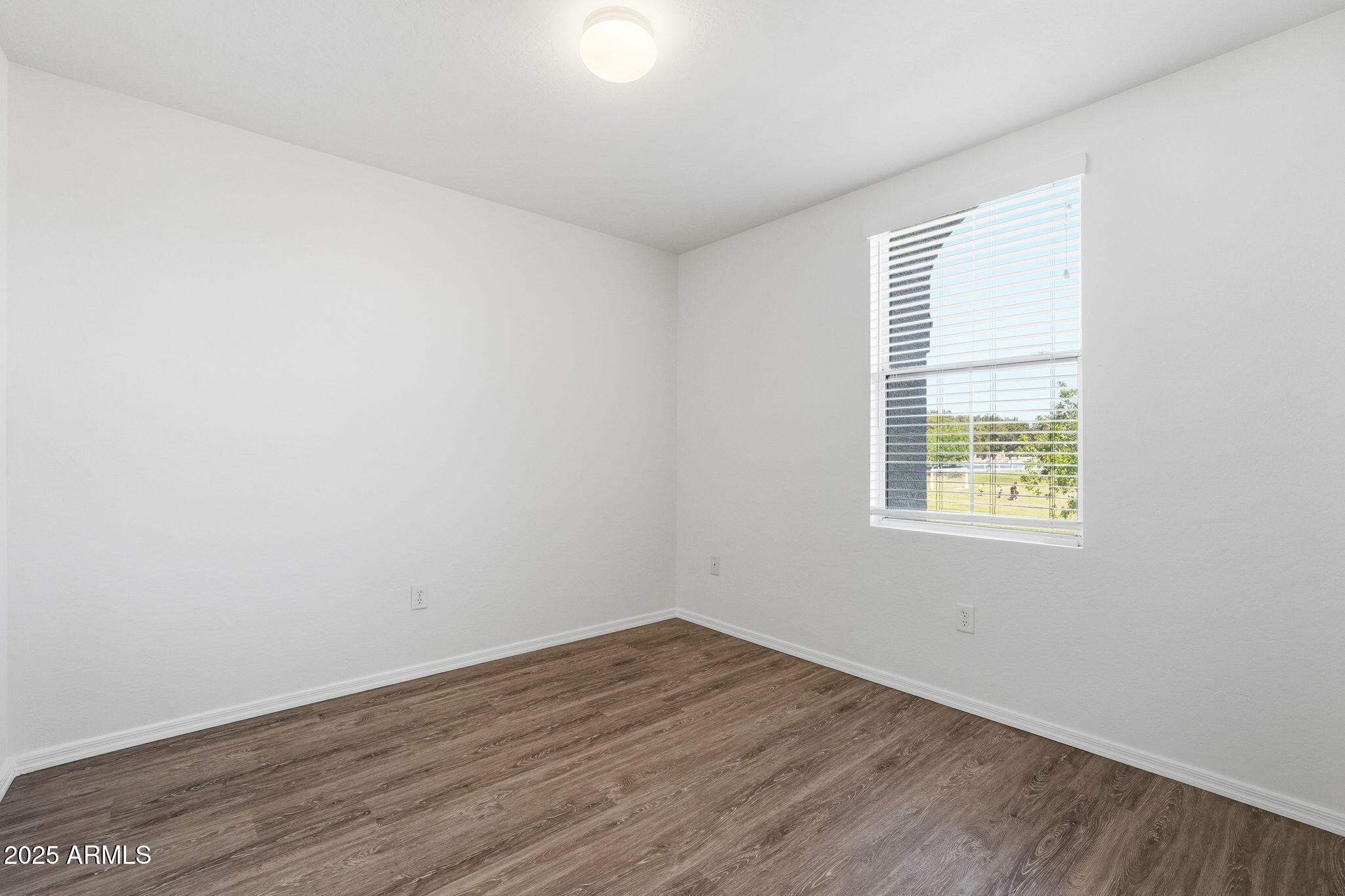 9233 East Neville Avenue, Unit 1136 Mesa, AZ 85209 - Photo 18 of 29 an empty room with wooden floor and windows