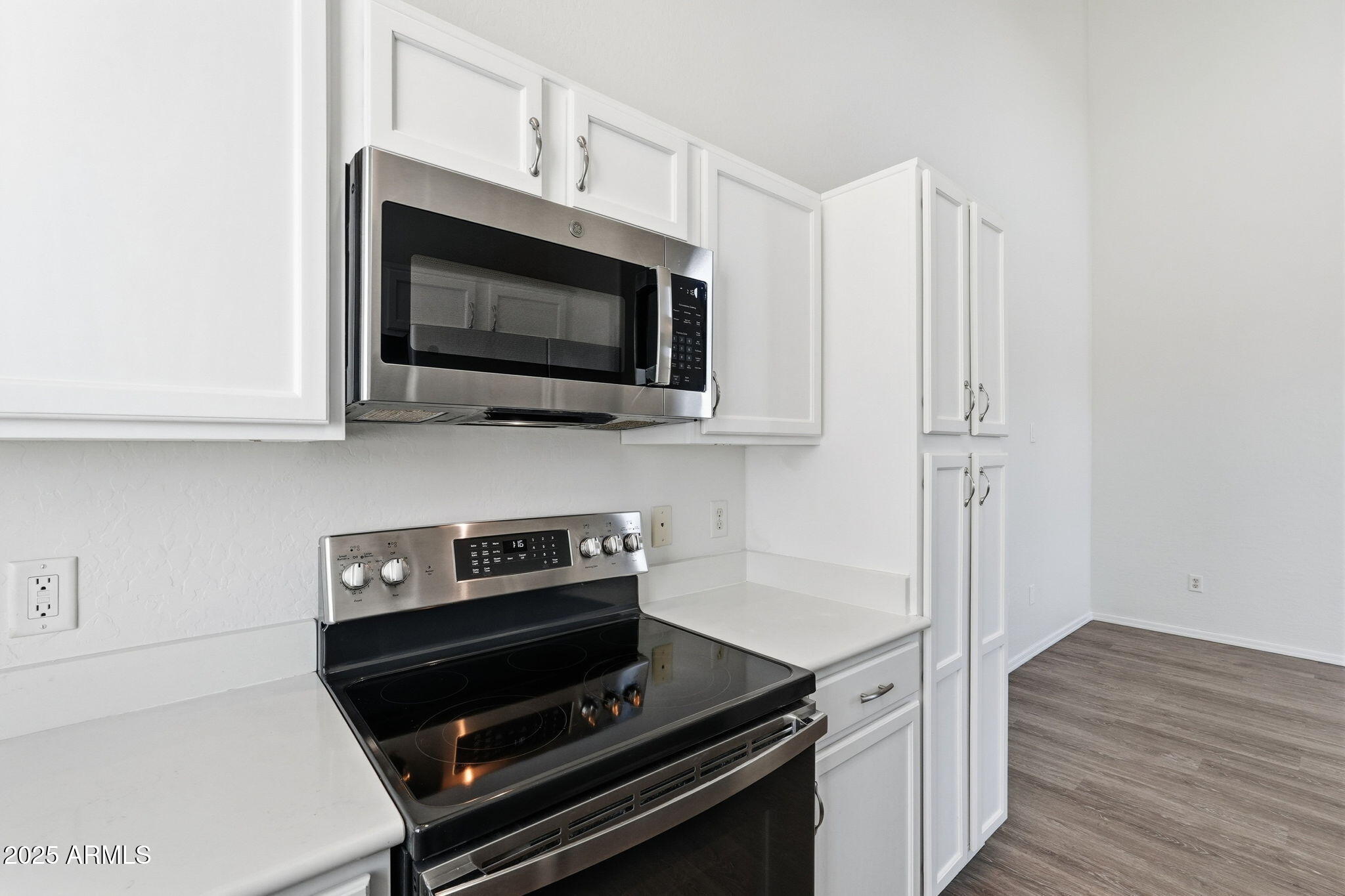 9233 East Neville Avenue, Unit 1136 Mesa, AZ 85209 - Photo 9 of 29 a kitchen with wooden floor and steel appliances