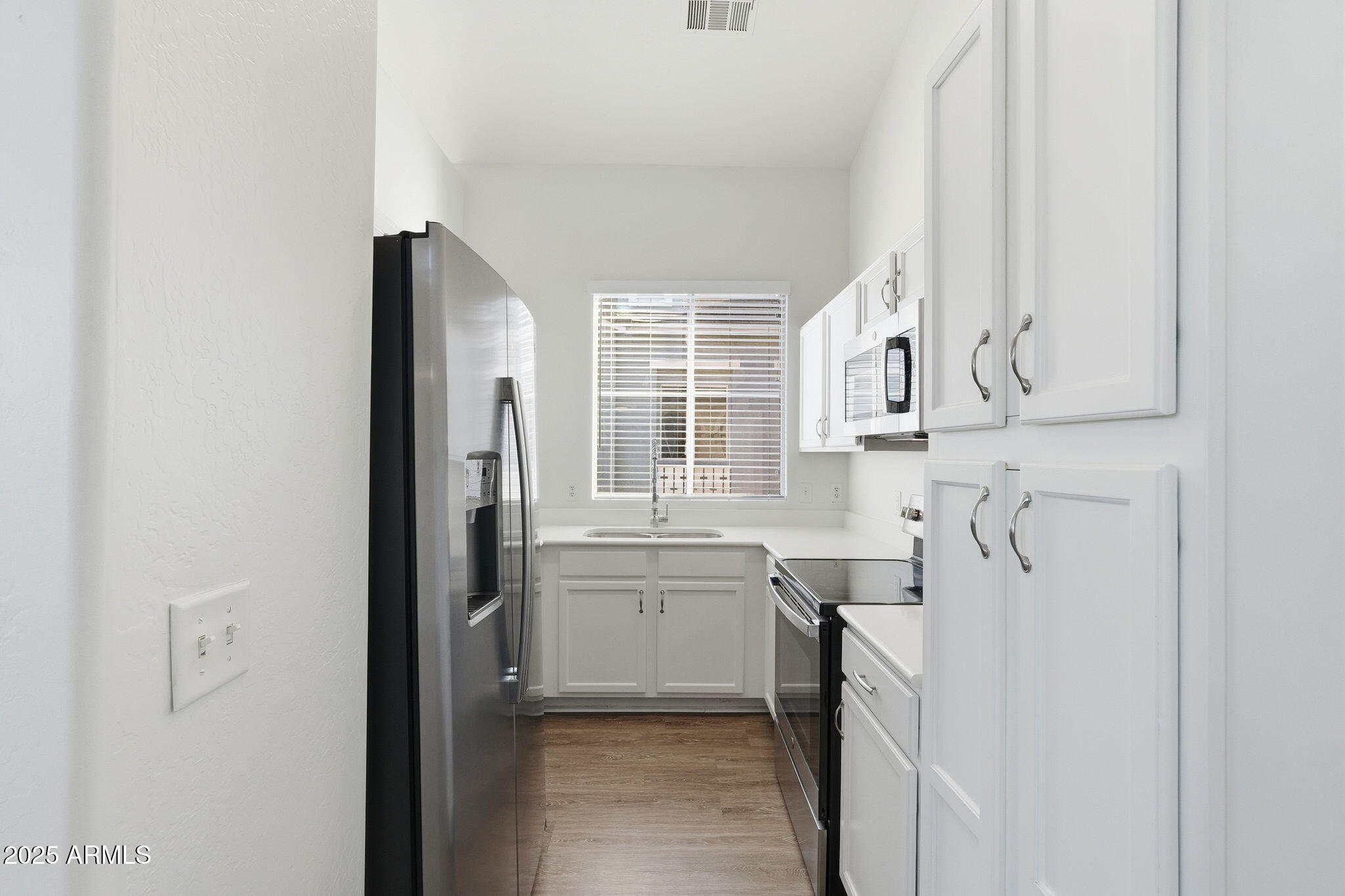 9233 East Neville Avenue, Unit 1136 Mesa, AZ 85209 - Photo 10 of 29 a kitchen with stainless steel appliances granite countertop a sink and dishwasher a refrigerator with white cabinets