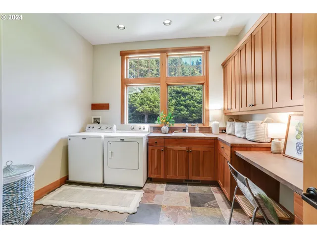 a utility room with cabinets a sink and a window