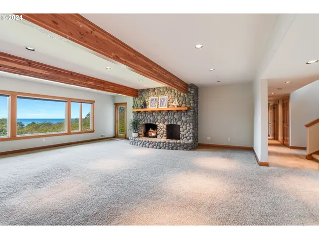 a view of an empty room with a fireplace and a window