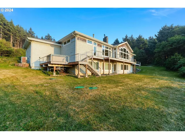 a view of a white house with a big yard and sitting area
