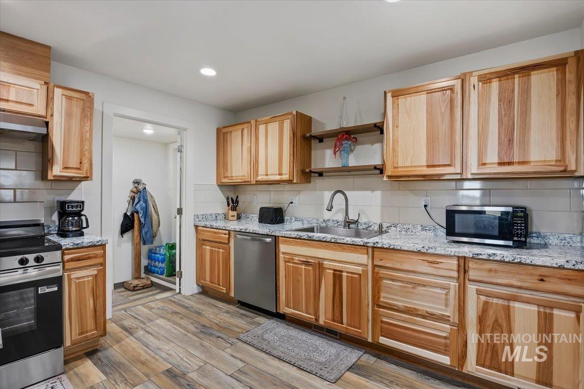 3536 North 2300 E Road Filer, ID 83328 - Photo 8 of 47 Kitchen featuring stainless steel appliances, light wood-style floors, light stone counters, backsplash, and recessed lighting