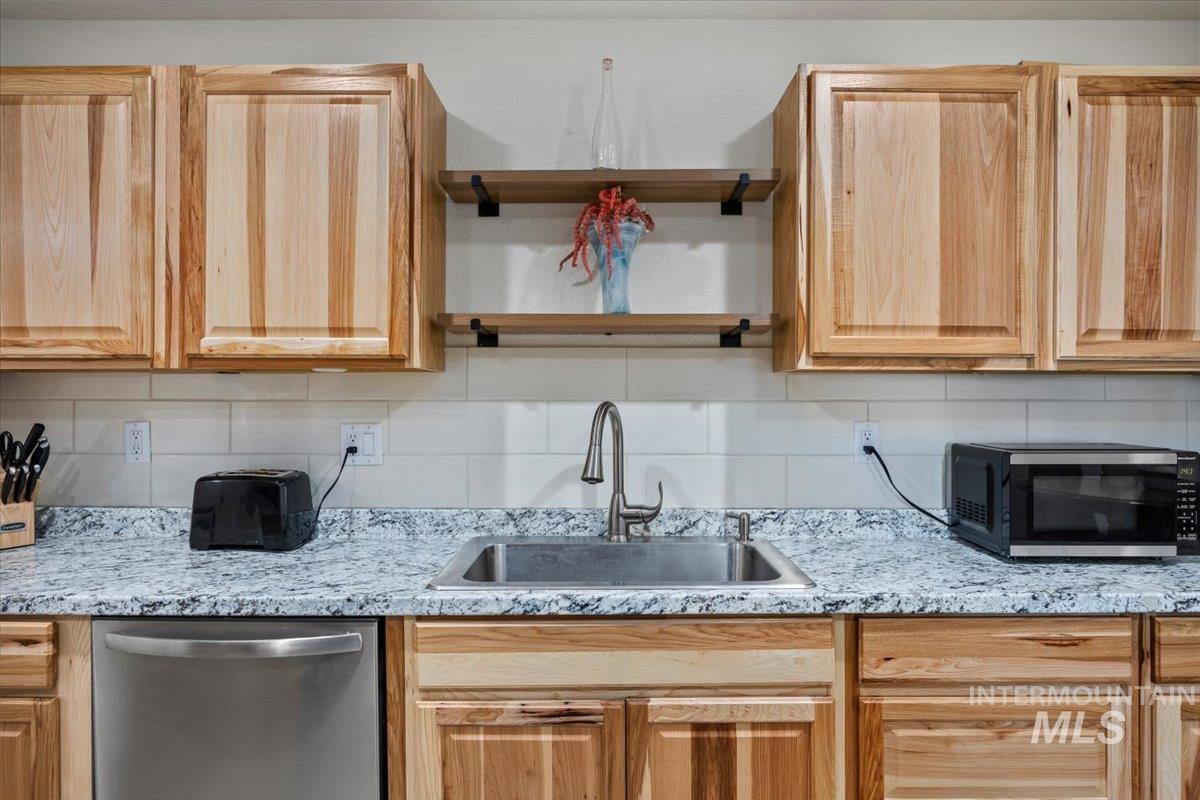 3536 North 2300 E Road Filer, ID 83328 - Photo 9 of 47 Kitchen with stainless steel appliances, backsplash, light wood finish cabinets, and light stone counters