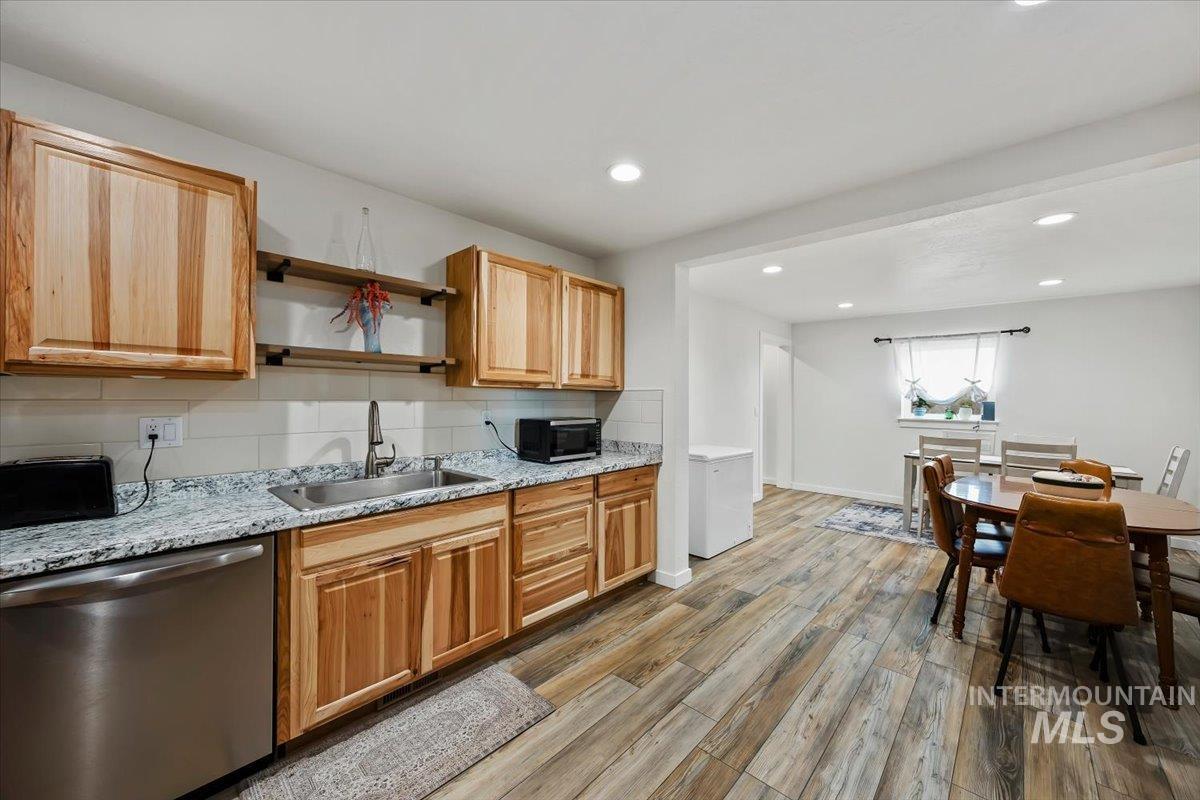 3536 North 2300 E Road Filer, ID 83328 - Photo 11 of 47 Kitchen featuring stainless steel appliances, backsplash, light wood finished floors, light stone counters, and recessed lighting