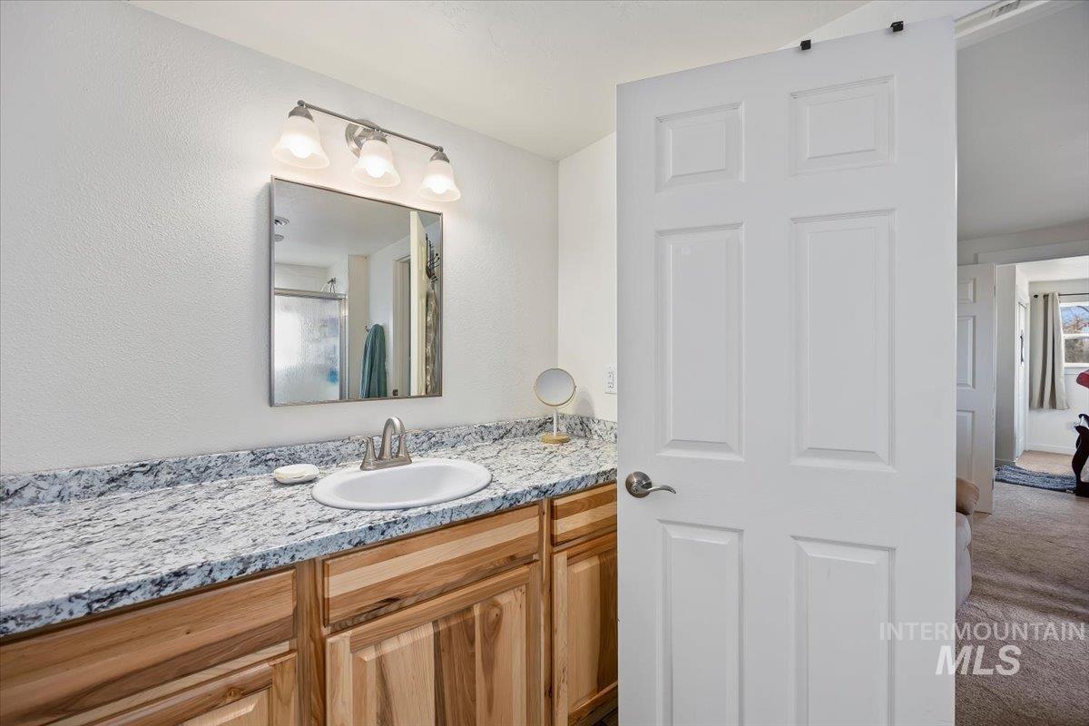 3536 North 2300 E Road Filer, ID 83328 - Photo 23 of 47 Full bath with vanity, a shower with shower door, and carpet floors