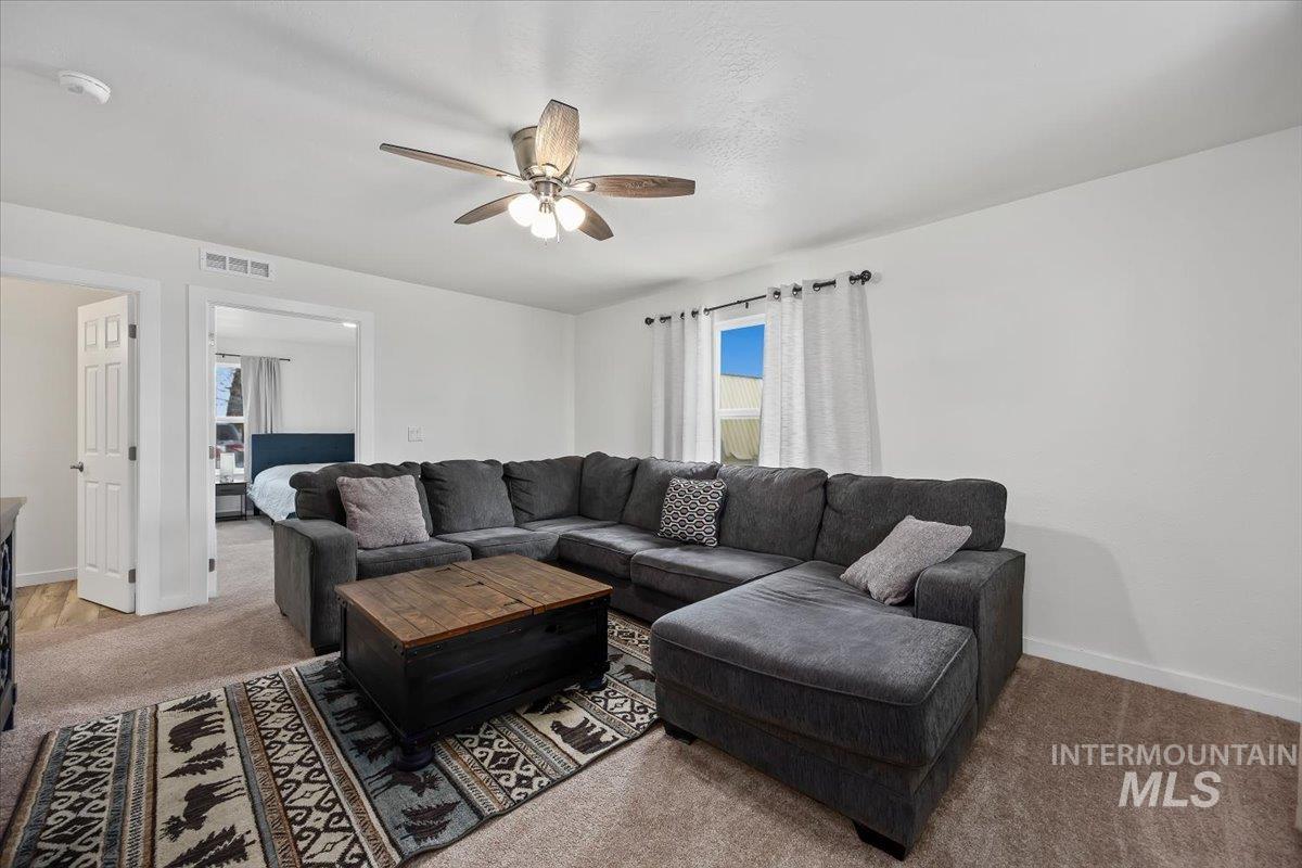 3536 North 2300 E Road Filer, ID 83328 - Photo 4 of 47 Living room with light carpet and ceiling fan