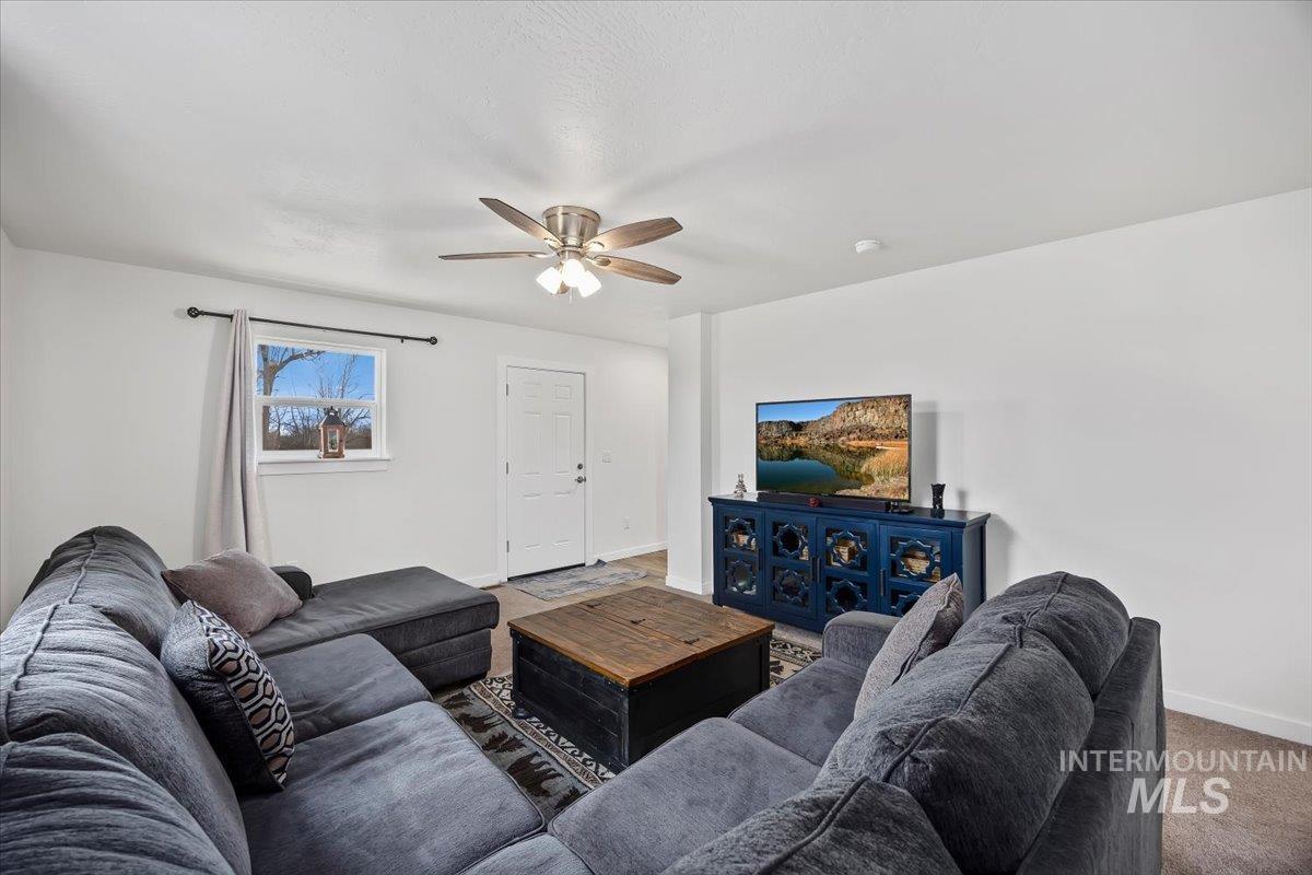 3536 North 2300 E Road Filer, ID 83328 - Photo 5 of 47 Living room featuring carpet and a ceiling fan