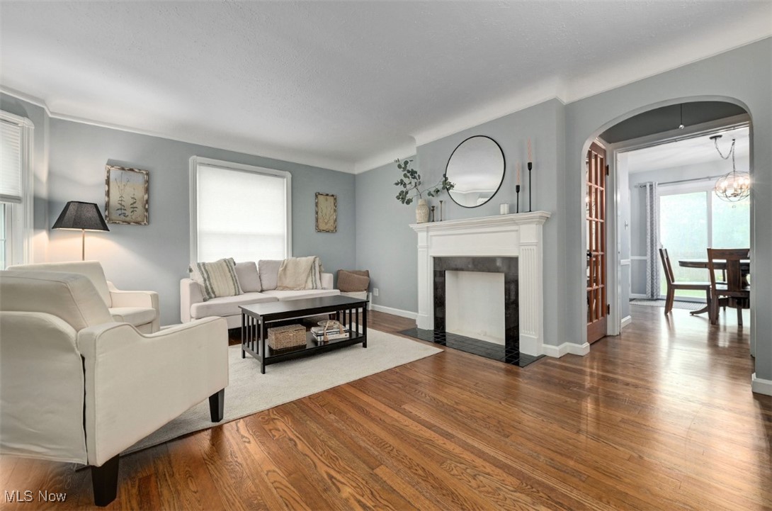 16501 Munn Road Cleveland, OH 44111 - Photo 5 of 42 Living room featuring dark wood-style floors, a premium fireplace, and arched walkways