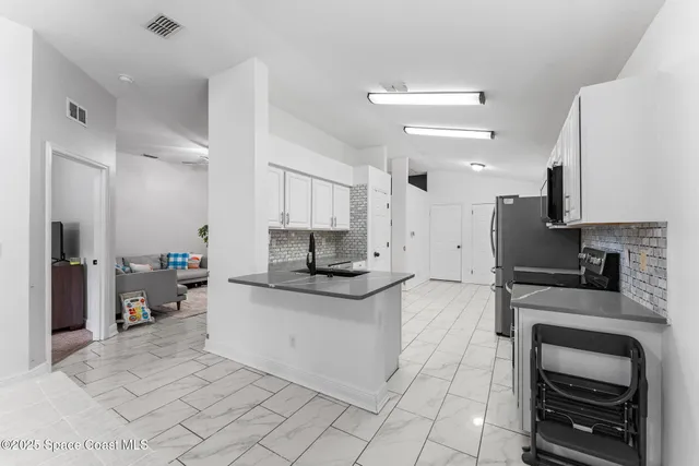 a kitchen with stainless steel appliances a stove a sink and a refrigerator