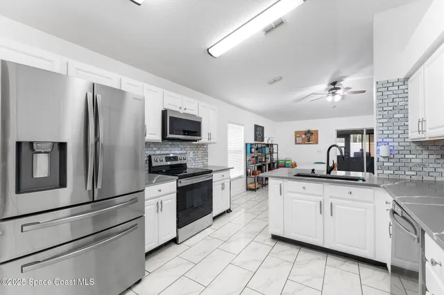 a kitchen with granite countertop a sink stainless steel appliances and cabinets