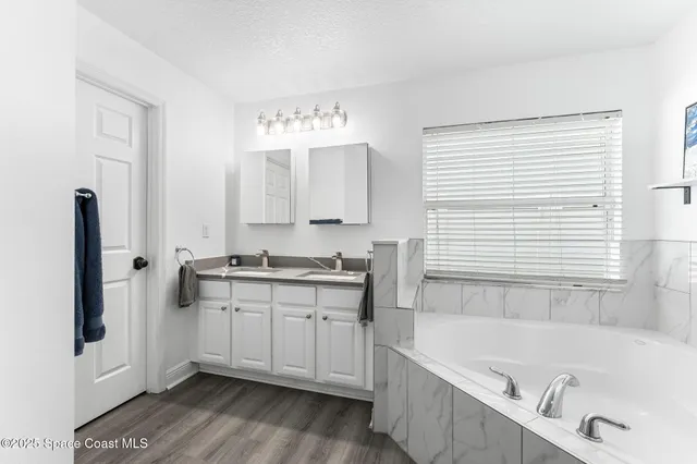 a bathroom with a tub sink and a mirror