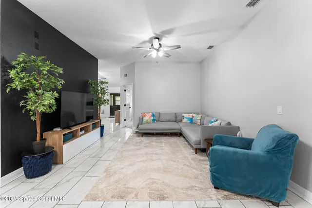 a living room with furniture and a potted plant