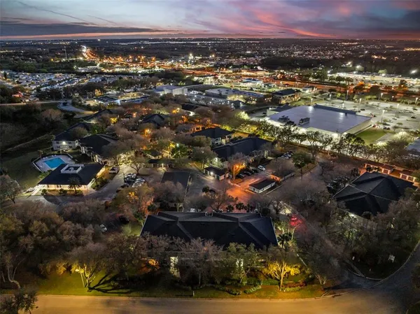 an aerial view of residential houses with outdoor space and trees