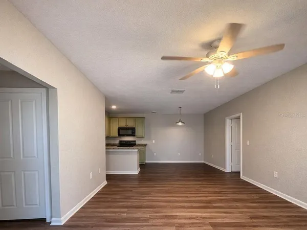 a view of a kitchen with wooden floor and a ceiling fan