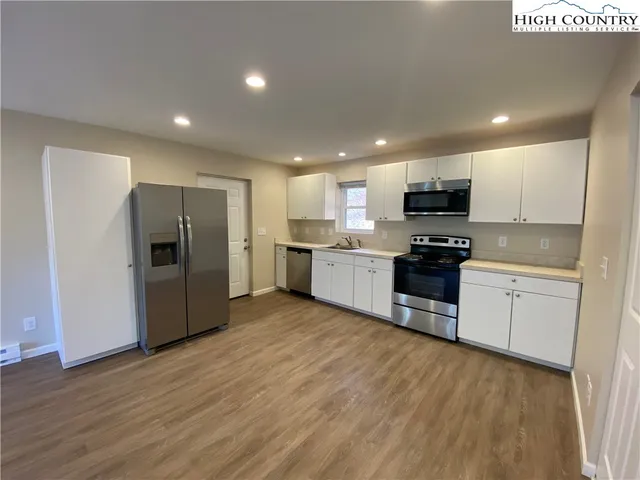 a kitchen with stainless steel appliances granite countertop a refrigerator and a stove top oven