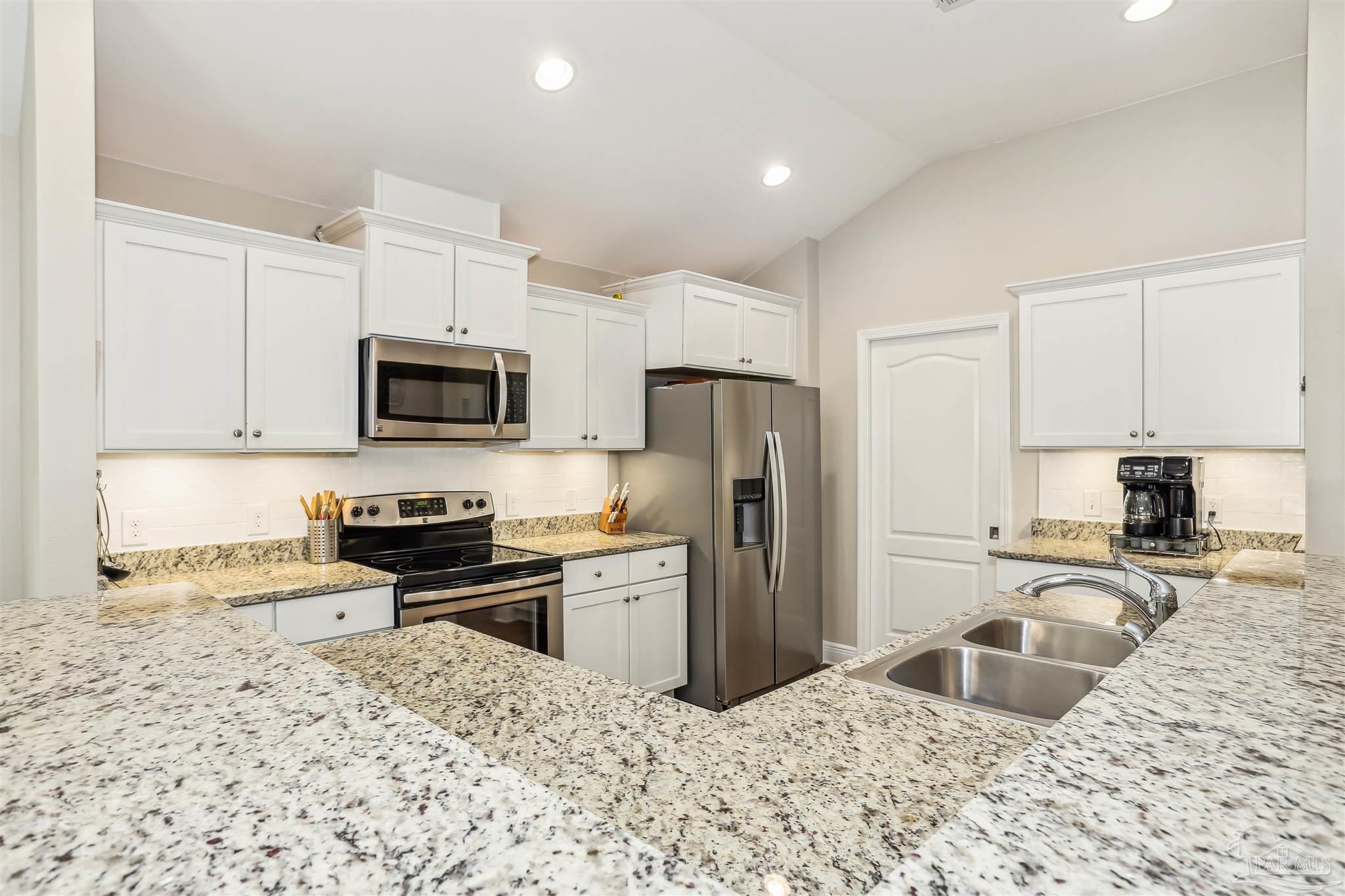 7305 Farmers Road Pensacola, FL 32526 - Photo 12 of 47 a kitchen with granite countertop a refrigerator stove microwave and sink