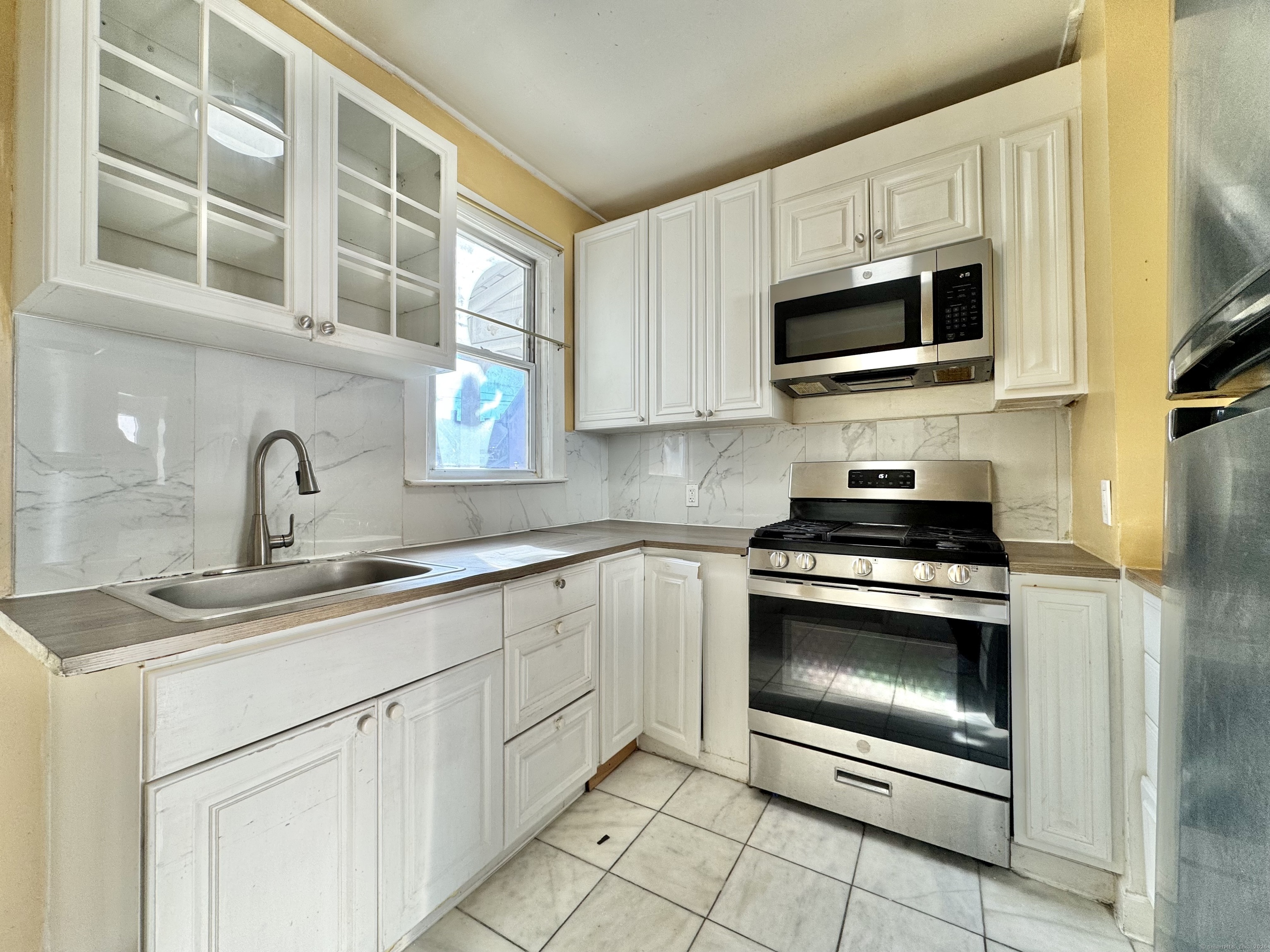 Undisclosed Address Bridgeport, CT 06608 - Photo 6 of 18 a kitchen with white cabinets stainless steel appliances and a sink