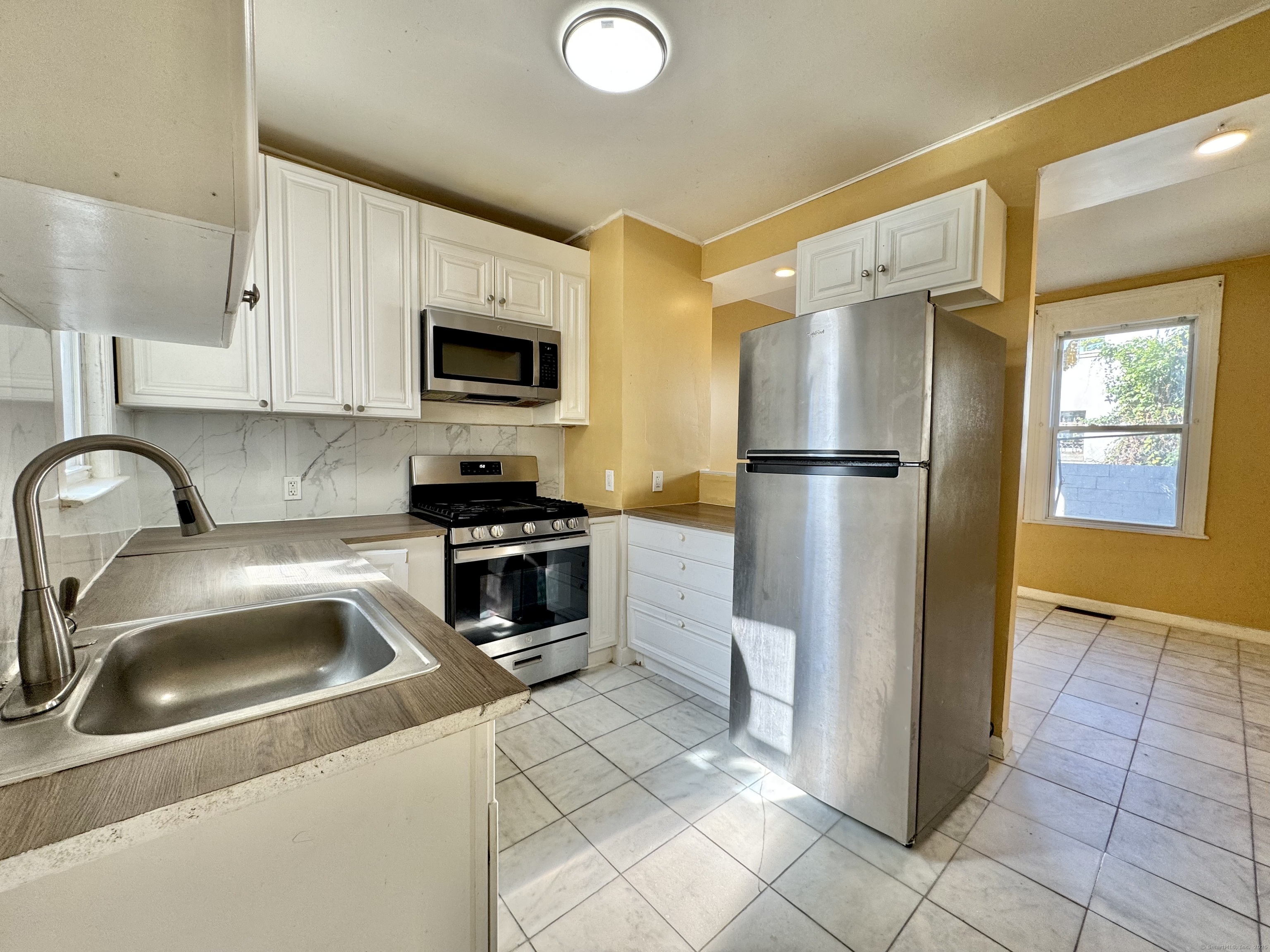 Undisclosed Address Bridgeport, CT 06608 - Photo 7 of 18 a kitchen with a refrigerator sink and cabinets