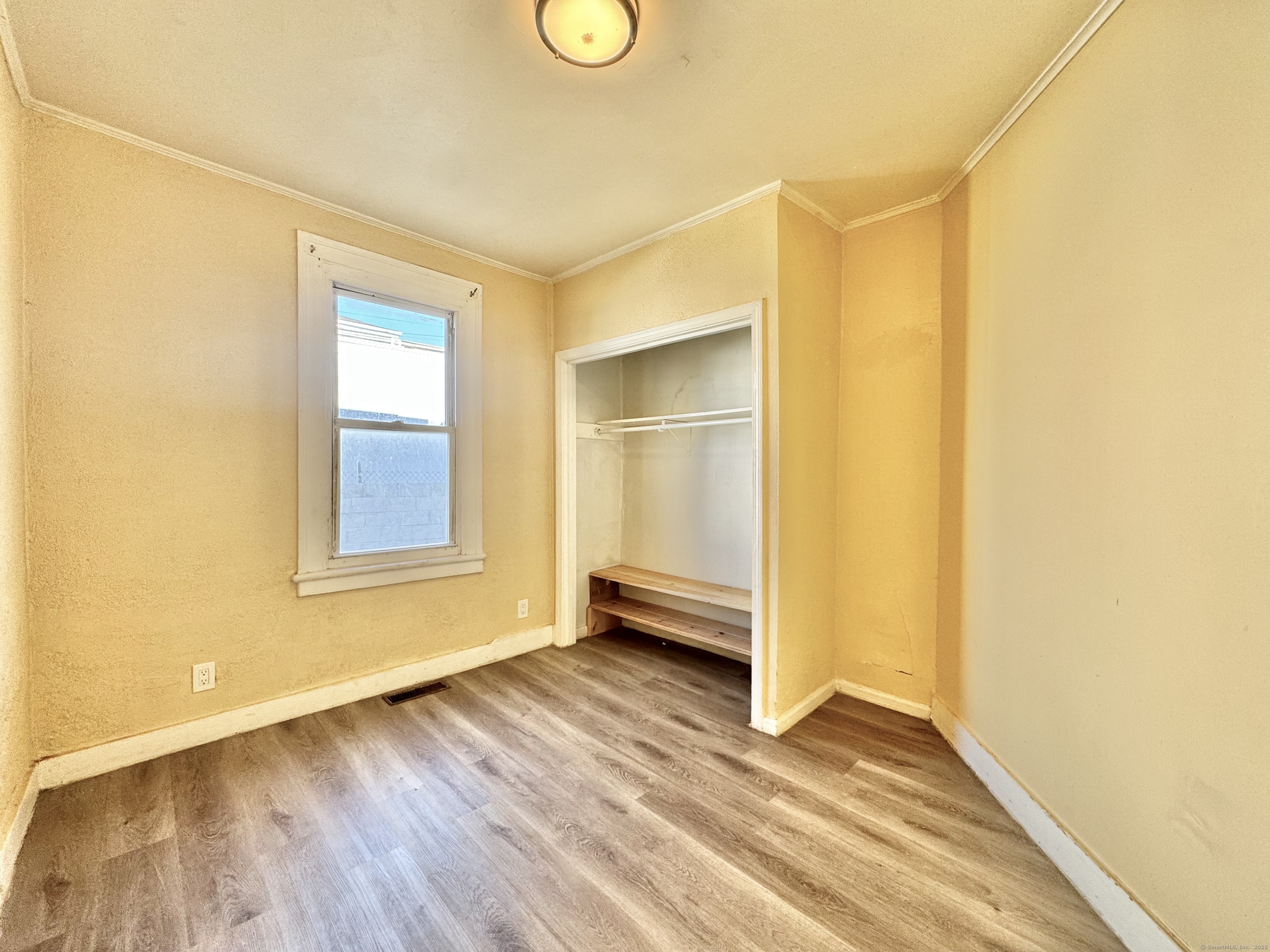Undisclosed Address Bridgeport, CT 06608 - Photo 10 of 18 a view of an empty room with wooden floor and a window