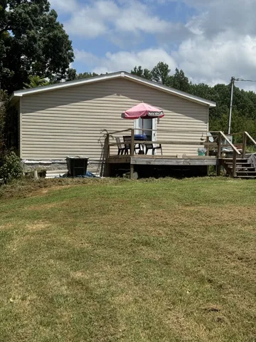 a view of a house with backyard and sitting area
