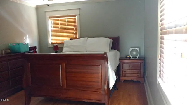 a bed sitting in a bedroom next to a window