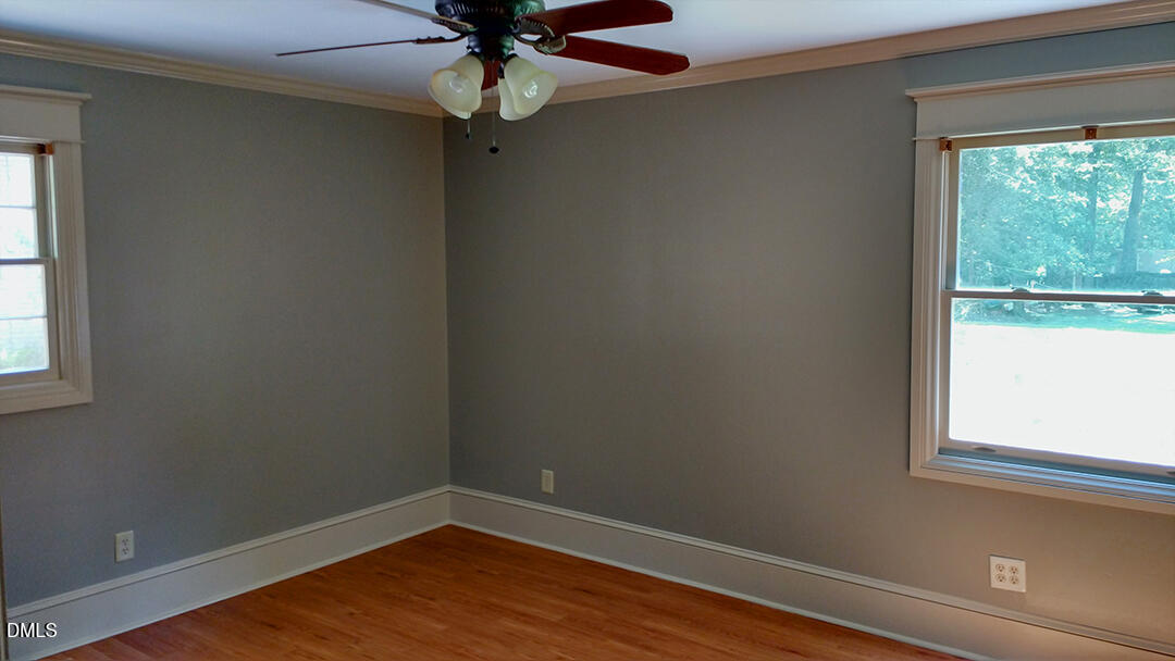6404 Buffaloe Road Raleigh, NC 27616 - Photo 5 of 12 an empty room with wooden floor fan and windows