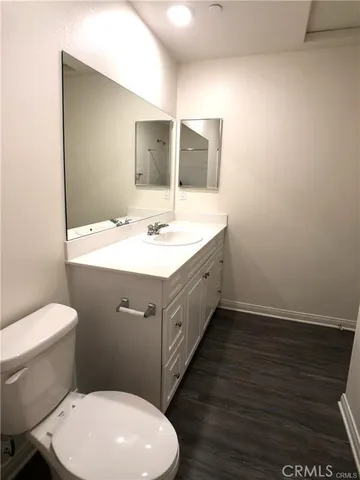 a bathroom with a granite countertop toilet sink and mirror