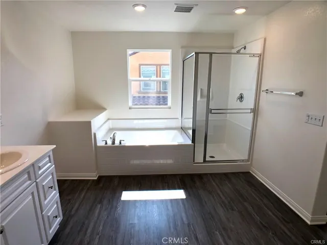 a view of walk in closet with wooden floor