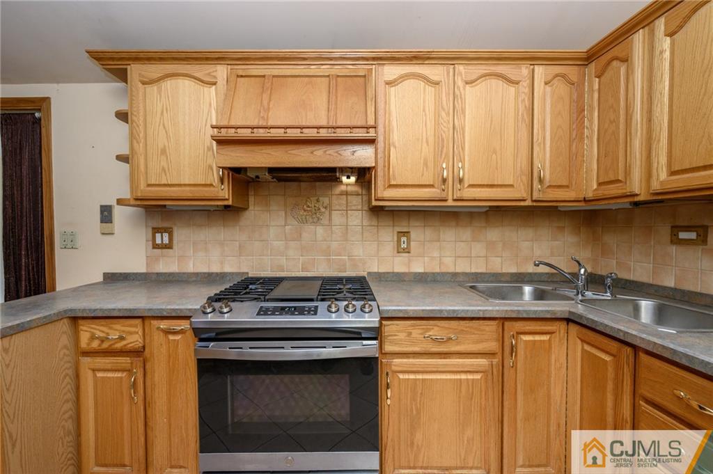 7 Florence Drive Sayreville, NJ 08859 - Photo 14 of 42 a kitchen with stainless steel appliances granite countertop a stove a sink and white cabinets