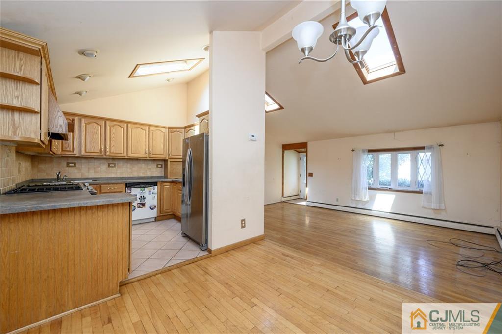 7 Florence Drive Sayreville, NJ 08859 - Photo 9 of 42 a kitchen with stainless steel appliances granite countertop a refrigerator a sink dishwasher a stove and white countertops with wooden floor