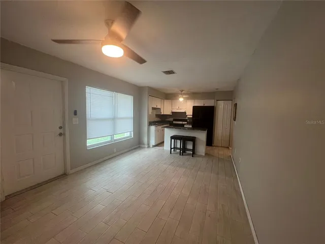 an empty room with furniture and a ceiling fan