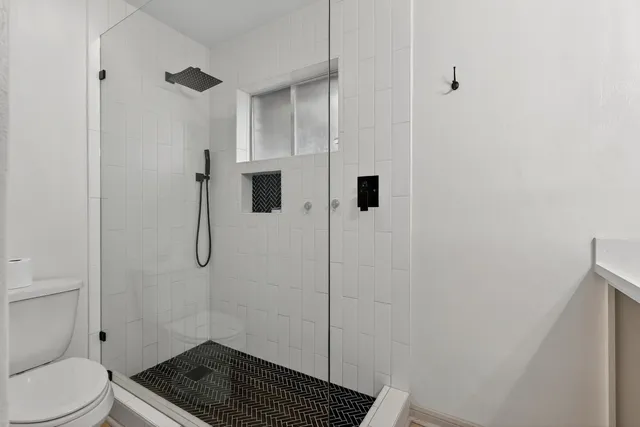 a bathroom with a toilet and a shower