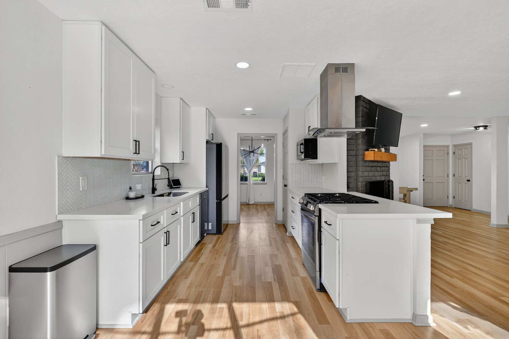 16122 Rill Lane Houston, TX 77062 - Photo 6 of 23 a large kitchen with stainless steel appliances kitchen island a stove a refrigerator a oven and white cabinets with wooden floor
