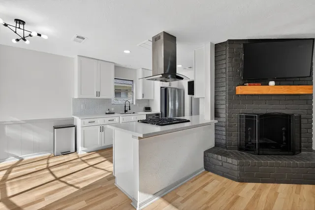 a kitchen with stainless steel appliances granite countertop a stove top oven and cabinets