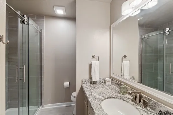 a bathroom with a granite countertop double vanity sink and mirror