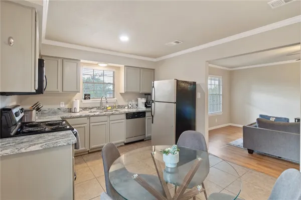 a kitchen with a refrigerator and a stove top oven