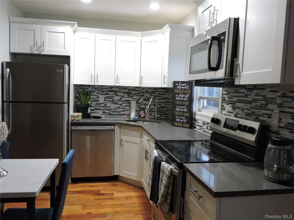 a kitchen with granite countertop a refrigerator stove and sink