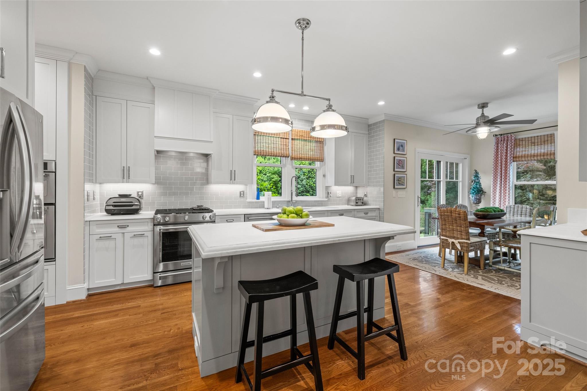 2329 Club Road Charlotte, NC 28205 - Photo 16 of 48 a kitchen with stainless steel appliances a dining table chairs stove refrigerator and sink