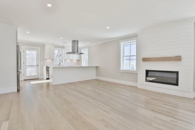 a view of empty room with wooden floor and fireplace