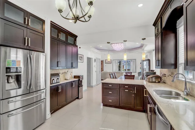a kitchen with stainless steel appliances granite countertop a sink a stove and a refrigerator