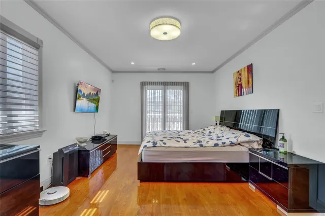a bedroom with a bed and wooden floor